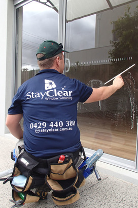 Window cleaner in Littlehampton using a squegee